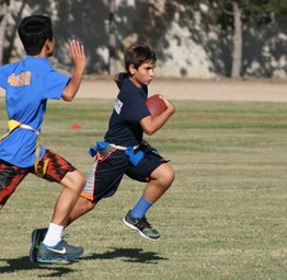 boys playing flag football on field